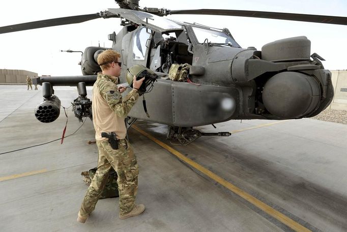 Britain's Prince Harry stands by an Apache helicopter in Camp Bastion, southern Afghanistan in this photograph taken October 31, 2012, and released January 21, 2013. The Prince, who is serving as a pilot/gunner with 662 Squadron Army Air Corps, is on a posting to Afghanistan that runs from September 2012 to January 2013. Photograph taken October 31, 2012. Photograph pixelated at source. REUTERS/John Stillwell/Pool (AFGHANISTAN - Tags: MILITARY POLITICS SOCIETY ROYALS CONFLICT) Published: Led. 21, 2013, 7:39 odp.