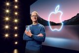 Šéf technologického giganta Apple Tim Cook drží nový iPhone. V pozadí vidíte notoricky známé logo společnosti - nakousnuté jablko.