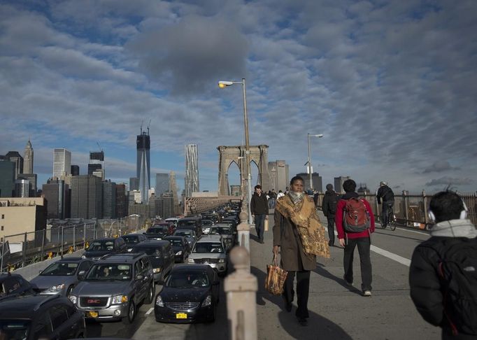 Po sérii neklidných dnů, kdy oblohu na New Yorkem zakrývala hustá oblaka, zde konečně prosvitlo modré nebe. Pohled na lidi přecházející slavný Brooklyn Bridge.