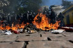 Riot policemen stand behind burning rubbish during a protest against the 2014 World Cup in Sao Paulo June 12, 2014. REUTERS/Ricardo Moraes (BRAZIL - Tags: SPORT SOCCER WO
