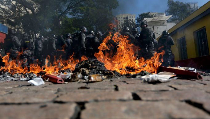 Riot policemen stand behind burning rubbish during a protest against the 2014 World Cup in Sao Paulo June 12, 2014. REUTERS/Ricardo Moraes (BRAZIL - Tags: SPORT SOCCER WO