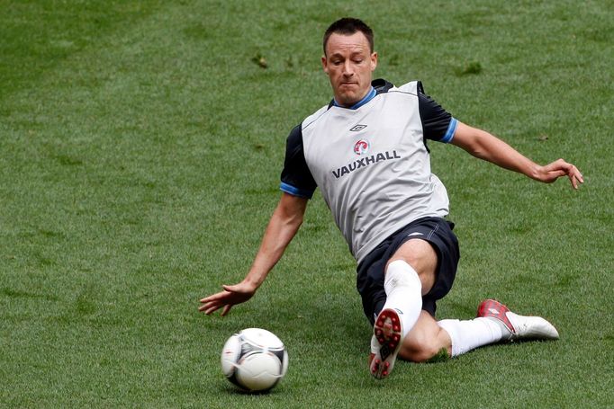 Anglický obránce John Terry sklouzává pro míč během tréninku reprezentace před Eurem 2012.