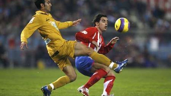 Jose Manuel Jurado z Atlétika Madrid (vpravo) v souboji s hráčem Tarragony Alejandro Campanem.