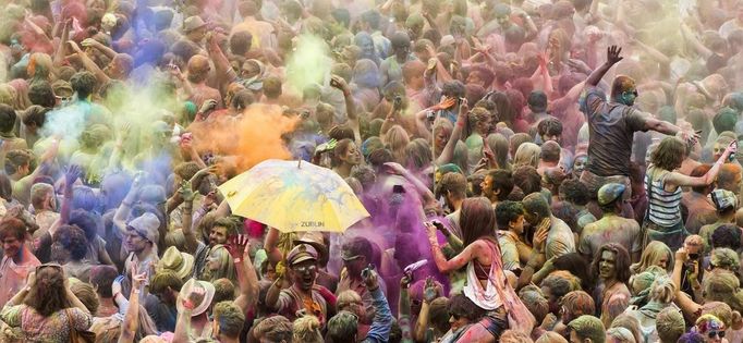 People throw coloured powder in the air during Holi festival celebrations in Berlin, July 29, 2012. Holi, also known as the festival of colours, is a festival celebrated in India and other Hindu countries that in its original form heralds the beginning of spring. The Berlin event brought Indian Djs, acrobatics and dance to the German capital. REUTERS/Thomas Peter (GERMANY - Tags: SOCIETY) Published: Čec. 29, 2012, 3:26 odp.