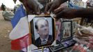 Malians display a picture of French President Francois Hollande for sale at a market in Bamako January 20, 2013. French troops in armoured vehicles advanced on Sunday towards a central Malian town abandoned by Islamist rebels after days of air strikes, moving cautiously for fear of guerrilla-style counterattacks by the al Qaeda-linked fighters. REUTERS/Eric Gaillard (MALI - Tags: CIVIL UNREST CONFLICT MILITARY) Published: Led. 20, 2013, 7:14 odp.