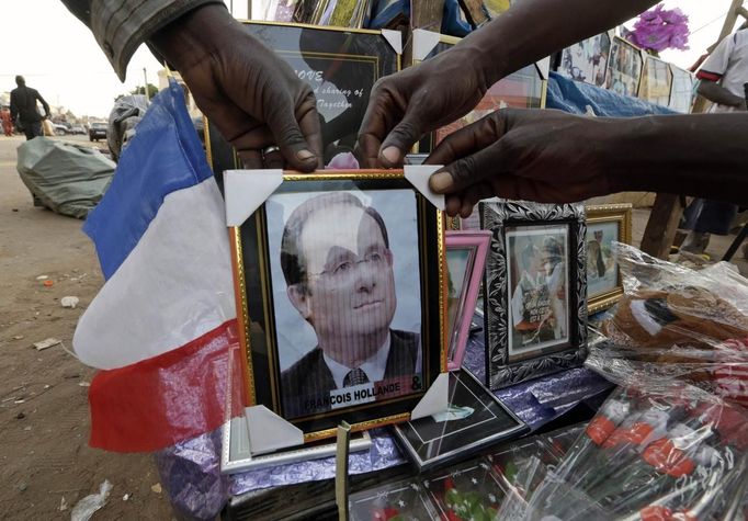 Malians display a picture of French President Francois Hollande for sale at a market in Bamako January 20, 2013. French troops in armoured vehicles advanced on Sunday towards a central Malian town abandoned by Islamist rebels after days of air strikes, moving cautiously for fear of guerrilla-style counterattacks by the al Qaeda-linked fighters. REUTERS/Eric Gaillard (MALI - Tags: CIVIL UNREST CONFLICT MILITARY) Published: Led. 20, 2013, 7:14 odp.