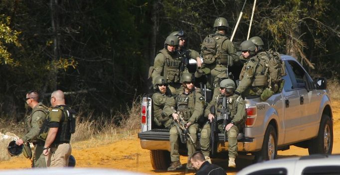 Law enforcement officials including the FBI are driven onto the scene of a shooting and hostage taking near Midland City, Alabama February 1, 2013. Residents in a rural Alabama town prayed on Friday and called for the release of a 5-year-old boy being held captive for a fourth day by a man accused of shooting a school bus driver and then taking the child hostage. REUTERS/Phil Sears (UNITED STATES - Tags: CRIME LAW) Published: Úno. 1, 2013, 9:33 odp.