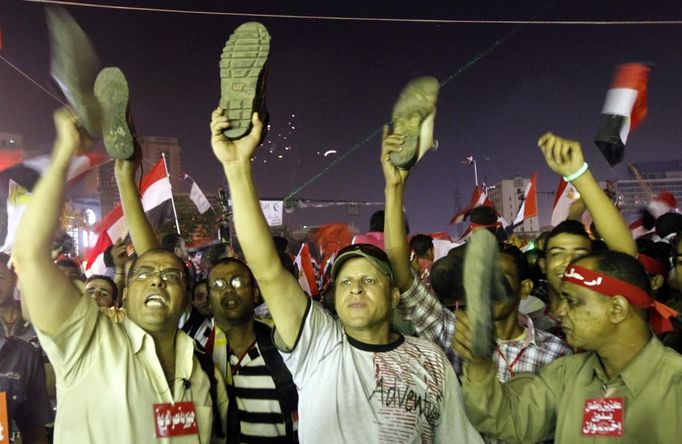 Anti-President Mohamed Mursi protesters hold up their shoes after a speech by Mursi, at Tahrir Square in Cairo July 3, 2013. Mursi vowed to stay in power and defend constitutional legitimacy with his life on Wednesday as generals worked on plans to push the Islamist aside within the day and suspend the constitution. REUTERS/Mohamed Abd El Ghany (EGYPT - Tags: POLITICS CIVIL UNREST) Published: Čec. 3, 2013, 1:39 dop.