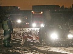 Policista odklání dopravu z dálnice, která musela být v noci ze soboty na neděli 18. prosince uzavřena kvůli hustému sněžení a dopravním nehodám.