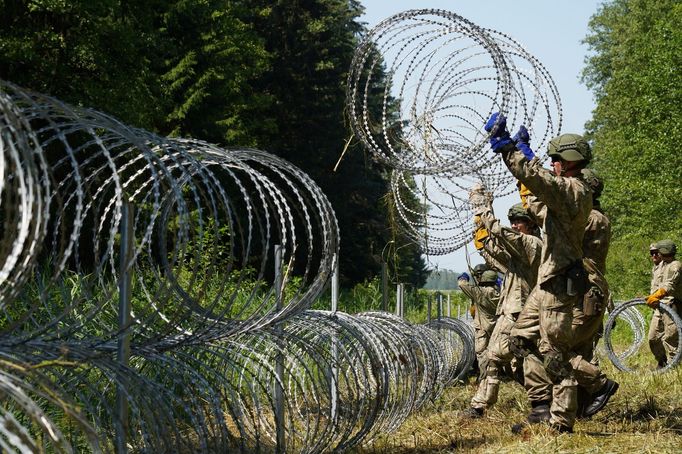 Ilustrační foto. Vojáci staví ostnatý drát na hranicích s Běloruskem, aby zabránili příchodu migrantů.