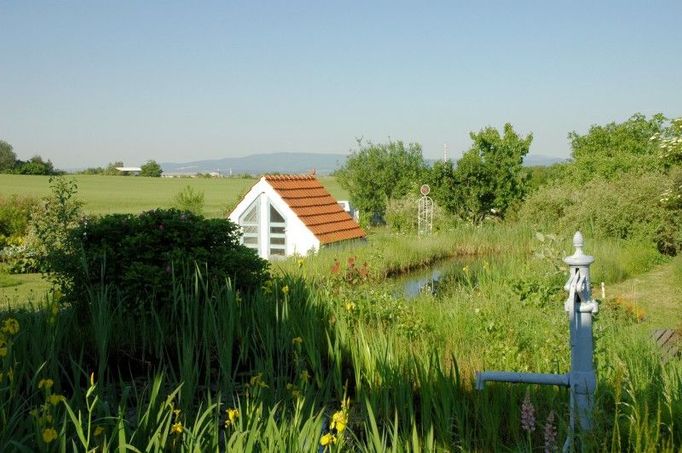 Přírodní zahrada s množstvím prvků (koupací biotop, bylinkové a trvalkové záhony, smíšené zeleninové kultury, skleník s přirozenou ventilací vzduchu, suché zídky, výběhy se zvířaty, zážitkové pískoviště pro děti, galerie venkovního skla). Text byl převzat ze stránek www.vikendotevrenychzahrad.cz  Více informací o uvedené zahradě můžete naleznout ZDE .