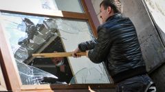 Proruský demonstrant rozbíjí okno v budově regionální vlády v Doněcku.