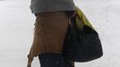 A homeless woman, her feet wrapped in plastic, walks in the snow in Paris March 12, 2013 as winter weather with snow and freezing temperatures returns to northern France. REUTERS/John Schults (FRANCE - Tags: ENVIRONMENT SOCIETY POVERTY) Published: Bře. 12, 2013, 1:03 odp.