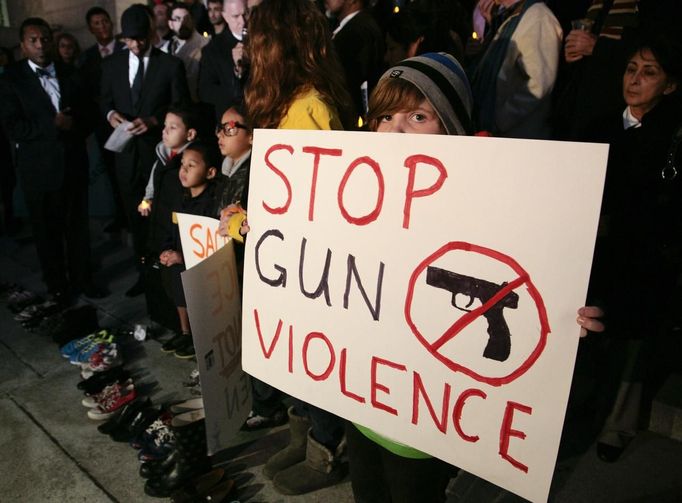 Sophie Bell, 9, holds a sign during an interfaith candlelight prayer vigil to end gun violence in front of Los Angeles City Hall in Los Angeles, California, December 19, 2012. A gunman killed 20 children and six adults in a shooting rampage at Sandy Hook Elementary School in Newtown, Connecticut on December 14. REUTERS/Jason Redmond (UNITED STATES - Tags: EDUCATION CRIME LAW RELIGION) Published: Pro. 20, 2012, 2:19 dop.