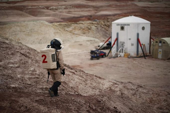 Csilla Orgel, a geologist of Crew 125 EuroMoonMars B mission, makes her way back to the Mars Desert Research Station (MDRS) in the Utah desert March 3, 2013. The MDRS aims to investigate the feasibility of a human exploration of Mars and uses the Utah desert's Mars-like terrain to simulate working conditions on the red planet. Scientists, students and enthusiasts work together developing field tactics and studying the terrain. All outdoor exploration is done wearing simulated spacesuits and carrying air supply packs and crews live together in a small communication base with limited amounts of electricity, food, oxygen and water. Everything needed to survive must be produced, fixed and replaced on site. Picture taken March 3, 2013. REUTERS/Jim Urquhart (UNITED STATES - Tags: SCIENCE TECHNOLOGY SOCIETY ENVIRONMENT) ATTENTION EDITORS: PICTURE 25 OF 31 FOR PACKAGE 'MARS IN THE DESERT' SEARCH 'JIM MARS' FOR ALL IMAGES Published: Bře. 11, 2013, 2:07 odp.