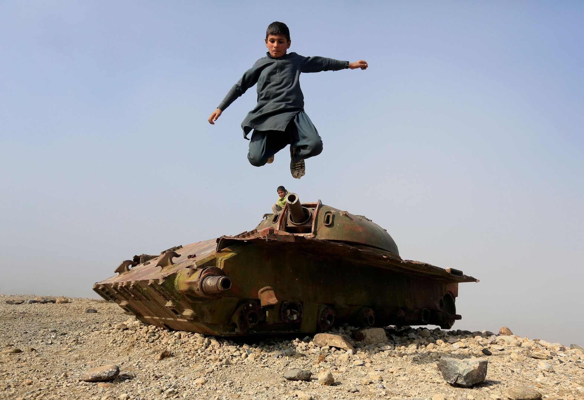 Chlapec v Afghánistánu skáče z pozůstatku sovětského tanku