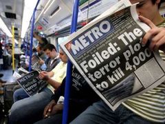 Cestující v londýnském metru míří na letiště Heathrow a čte si při tom ranní noviny.