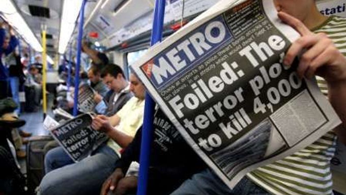 Cestující v londýnském metru míří na letiště Heathrow a čte si při tom ranní noviny.