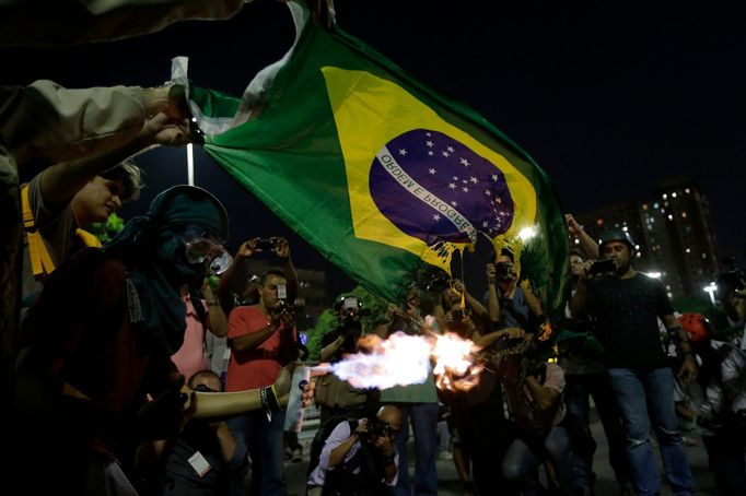 Demonstrators burn a Brazilian flag during a protest against the 2014 World Cup in Rio de Janeiro May 15, 2014. Brazilians opposed to the World Cup and the public funds s