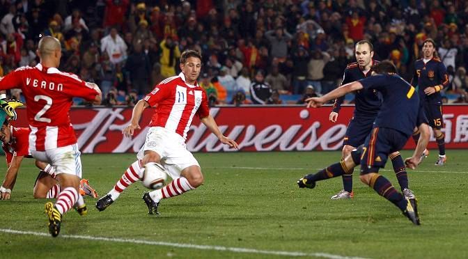David Villa obstřeluje obránce. Za pár vteřin se bude radovat z gólu