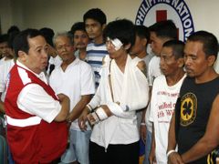 Senátor Richard Gordon, šéf filipínského Červeného kříže, mluví s přeživšími z potopeného trajektu Princess of the Stars