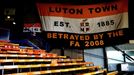 Vlajka, která připomíná, že Lutonu v roce 2008 odečetla anglická ligová asociace 30 bodů.