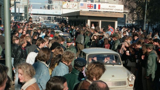 Obyvatelé západního Berlína u Checkpointu Charlie vítají trabanty Východoberlíňanů po pádu Berlínské zdi, 10. listopad 1989.