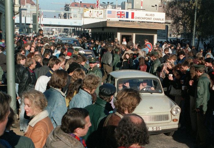 Obyvatelé západního Berlína u Checkpointu Charlie vítají trabanty Východoberlíňanů po pádu Berlínské zdi, 10. listopad 1989.