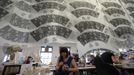 A worker applies tissue paper transfers to a cup, as others hang to dry in a workshop at the Middleport pottery in Stoke-on-Trent, central England January 22, 2013. The pottery which dates back to 1888 and was rescued from closure in 2009, continues to use traditional methods to produce its range of ceramics and famous Burleigh Ware pottery. REUTERS/Phil Noble (BRITAIN - Tags: BUSINESS EMPLOYMENT SOCIETY) Published: Led. 22, 2013, 4:33 odp.