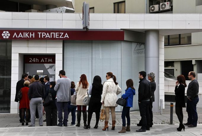 Lidé stojí frontu u bankomatu, který se nachází vedle zavřené pobočky kyperské banky Laiki Bank v Nikósii.