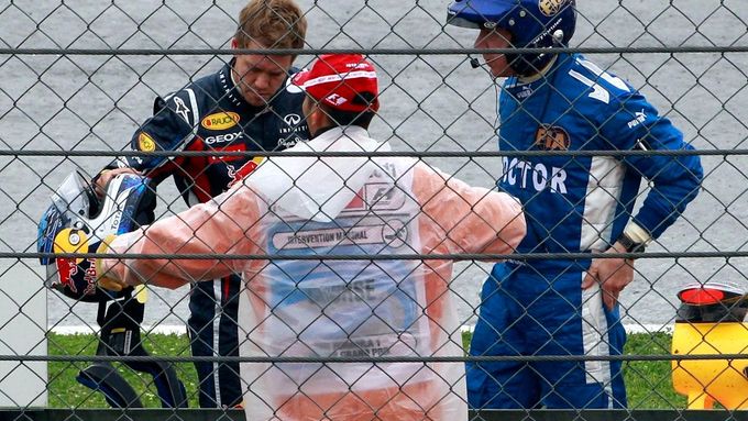 Sebastian Vettel mluví s doktorem po své havárii při tréninku na Velkou cenu Turecka.