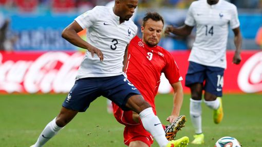 France's Evra fights for the ball with Switzerland's Seferovic during their 2014 World Cup Group E soccer match at the Fonte Nova arena in Salvador