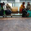 Passenger sleeps as others use laptop while waiting for flights with Lufthansa at Munich's airport