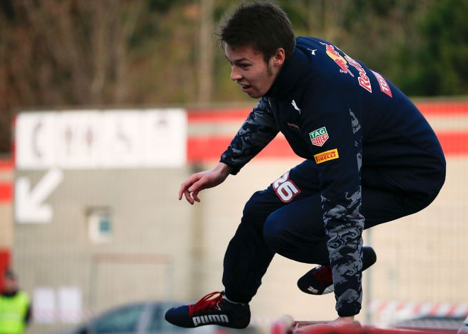 Red Bull Formula One driver Daniil Kvyat of Russia jumps a fence as he warms up in the paddock before the fourth testing session ahead the upcoming season at the Circuit