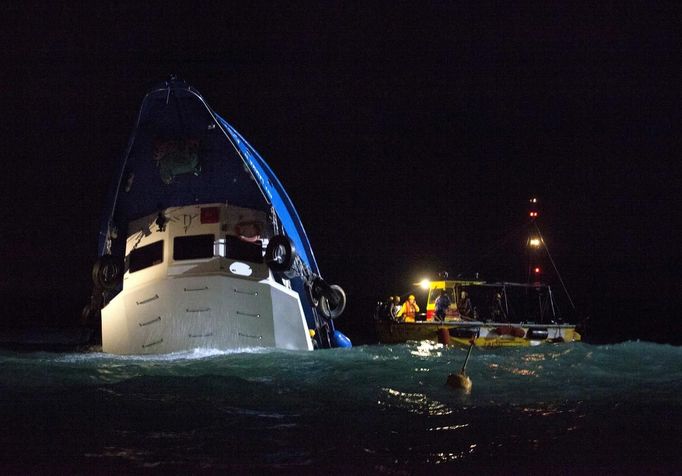 Rescuers search for survivors in a partially-submerged boat after two vessels collided in Hong Kong October 1, 2012. A major rescue is underway in the waters near Yung Shue Wan on Hong Kong's Lamma island following a collision involving two vessels in the evening, government radio reported on Monday. Police say there were about 100 people onboard both vessels, with many of them in the water. REUTERS/Tyrone Siu (CHINA - Tags: DISASTER TRANSPORT TPX IMAGES OF THE DAY) Published: Říj. 1, 2012, 3:56 odp.