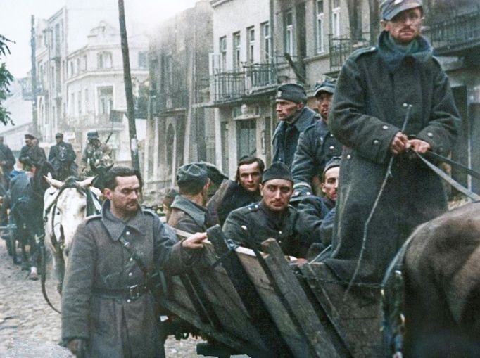 Polští vojáci zajatí ve Varšavě opouštějí město. Scéna z filmu „Feuertaufe“, režie Hans Bertram, Německo, 1940. Kolorovaný snímek