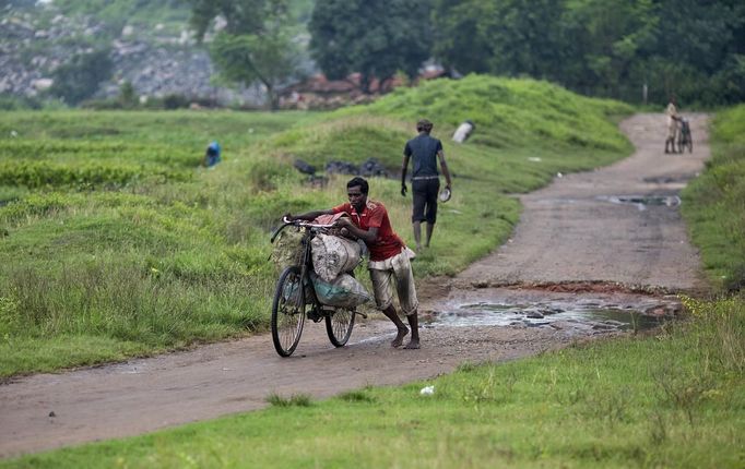 A local man carries sacks of coal on his bicycle taken from open coal field at Dhanbad district in the eastern Indian state of Jharkhand September 19, 2012. With oil and gas output disappointing and hydropower at full throttle, Asia's third-largest economy still relies on coal for most of its vast energy needs. About 75 percent of India's coal demand is met by domestic production and, according to government plans, that won't change over the next five years. Picture taken September 19, 2012. To match INDIA-COAL/ REUTERS/Ahmad Masood (INDIA - Tags: BUSINESS EMPLOYMENT ENERGY SOCIETY ENVIRONMENT) Published: Říj. 21, 2012, 10:16 odp.