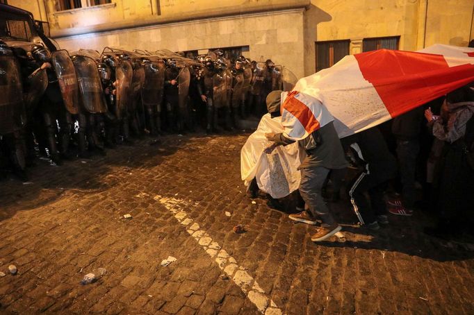 Strážci zákona zadržují muže během shromáždění proti zákonu o "zahraničních agentech" v gruzínském Tbilisi.