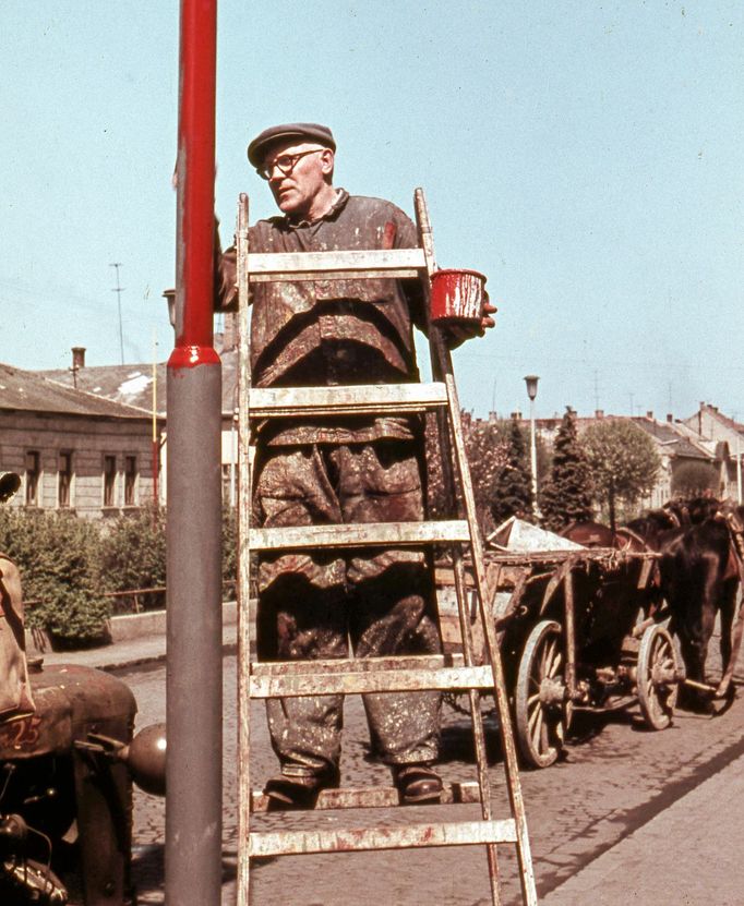 Muž provádí lakýrnické práce na lampě veřejného osvětlení v Novohradské ulici ve městě Lučenec. Rok 1963