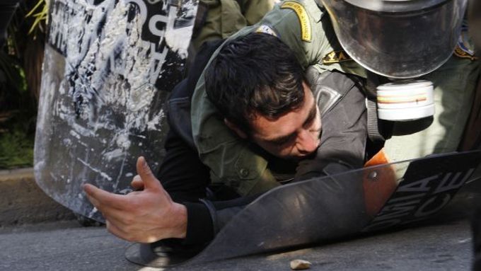 Policista a demonstrant se perou na aténské dlažbě. Něpokoje v řeckých městech zuří už druhým týdnem.