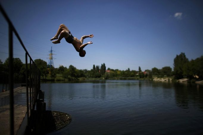 A boy jumps into the water of a lake on a warm summer day in Donetsk, June 22, 2012. REUTERS/Michael Buholzer (UKRAINE - Tags: SOCIETY ENVIRONMENT) Published: Čer. 22, 2012, 12:19 odp.