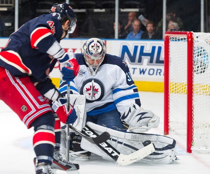 Ondřej Pavelec kryje střelu Arťoma Anisimova z NY Rangers