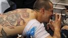 Ron Raucci from Norfolk, Virginia, reacts to the needle while getting his Captain America tattoo at the Hampton Roads Tattoo Festival in Virginia March 2, 2012. Raucci, who serves in the U.S. Navy, grew up reading Marvel comic books and has a leg tattoo collage featuring Captain America and Wolverine, his next planned tattoo will feature The Hulk. Picture taken March 2, 2012. REUTERS/Larry Downing (UNITED STATES - Tags: SOCIETY) ATTENTION EDITORS PICTURE 07 OF 31 FOR PACKAGE 'ADDICTED TO THE NEEDLE' TO FIND ALL PICTURES SEARCH 'ADDICTED NEEDLE' Published: Čer. 29, 2012, 12:59 odp.