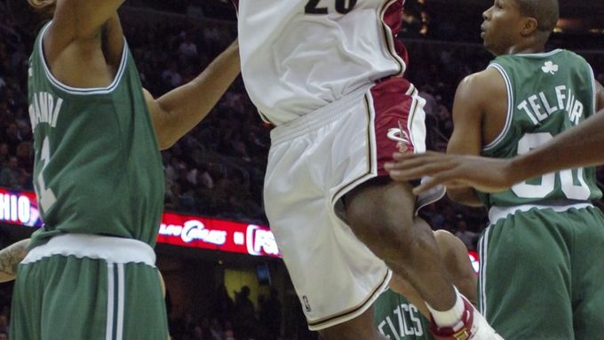 LeBron James z Clevelandu (v bílém) se snaží prosadit přes bostonského Michaela Olowokandiho.