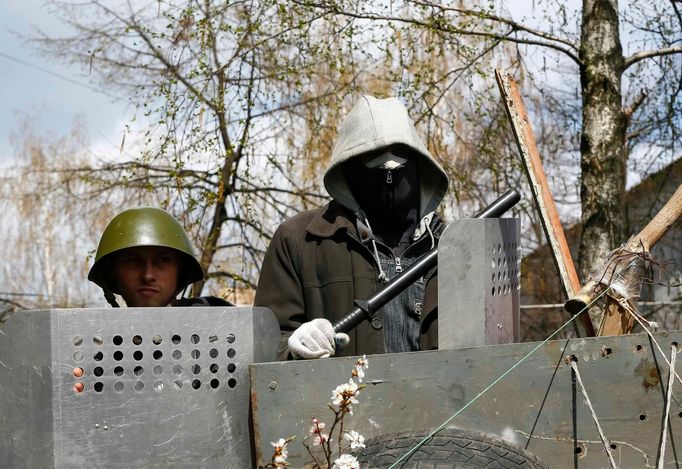 Pro-Russian protesters stand at barricades at the police headquarters in Slaviansk, April 15, 2014.