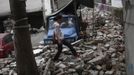 A woman walks among debris after Saturday's earthquake in Lushan county, April 22, 2013. Rescuers struggled to reach a remote, rural corner of southwestern China on Sunday as the toll of the dead and missing from the country's worst earthquake in three years climbed to 208 with almost 1,000 serious injuries. The 6.6 magnitude quake struck in Lushan county, near the city of Ya'an in the southwestern province of Sichuan, close to where a devastating 7.9 quake hit in May 2008, killing 70,000. REUTERS/Aly Song (CHINA - Tags: DISASTER SOCIETY) Published: Dub. 22, 2013, 3:50 dop.