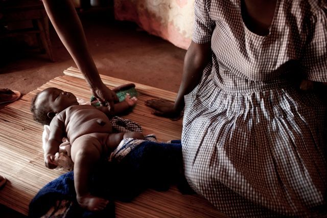 Uganda 2011 - bývalá dětská vojačka bez ruky s dítětem