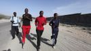 Somali athletes run along a street in Hodan district as they train during preparations for the 2012 London Olympic Games in Somalia's capital Mogadishu in this March 14, 2012 file photo. Training in a bullet-riddled stadium where the remains of a rocket propelled grenade lies discarded on the track's edge counts as progress for Somali Olympic hopeful Mohamed Hassan Mohamed. A year ago, Mogadishu's Konis stadium was a base for Islamist militants and a work out meant at times running through the streets, dodging gun-fire and mortar shells in one of the world's most dangerous cities. Picture taken March 14, 2012. To match OLY-SOMALIA-HOPES/ REUTERS/Feisal Omar/Files (SOMALIA - Tags: SPORT ATHLETICS SOCIETY OLYMPICS) Published: Čer. 11, 2012, 7:13 dop.