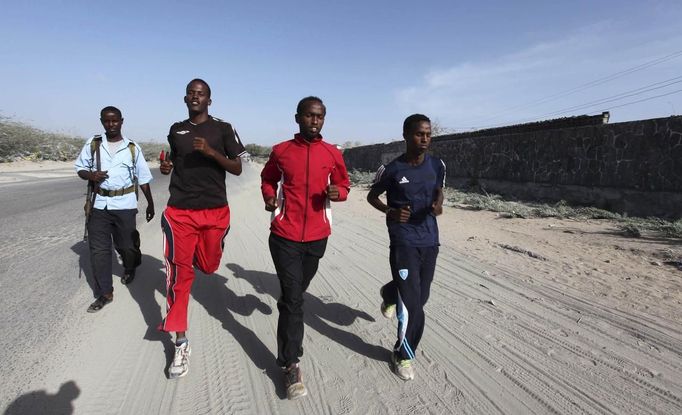 Somali athletes run along a street in Hodan district as they train during preparations for the 2012 London Olympic Games in Somalia's capital Mogadishu in this March 14, 2012 file photo. Training in a bullet-riddled stadium where the remains of a rocket propelled grenade lies discarded on the track's edge counts as progress for Somali Olympic hopeful Mohamed Hassan Mohamed. A year ago, Mogadishu's Konis stadium was a base for Islamist militants and a work out meant at times running through the streets, dodging gun-fire and mortar shells in one of the world's most dangerous cities. Picture taken March 14, 2012. To match OLY-SOMALIA-HOPES/ REUTERS/Feisal Omar/Files (SOMALIA - Tags: SPORT ATHLETICS SOCIETY OLYMPICS) Published: Čer. 11, 2012, 7:13 dop.