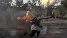 An Indonesian Muslim protester throws a Molotov cocktail towards the police during a protest in front of the U.S. embassy in Jakarta September 17, 2012. Indonesia police used teargas and water cannon on Monday to disperse hundreds of demonstrators who massed outside the U.S. embassy in Jakarta to protest against a film mocking the Prophet Mohammad. REUTERS/Beawiharta (INDONESIA - Tags: POLITICS CIVIL UNREST RELIGION) Published: Zář. 17, 2012, 9:56 dop.